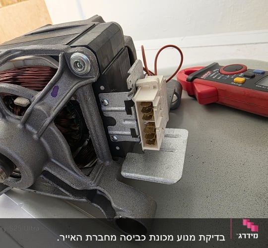 מנוע חשמלי ומד מתח על שולחן עבודה
